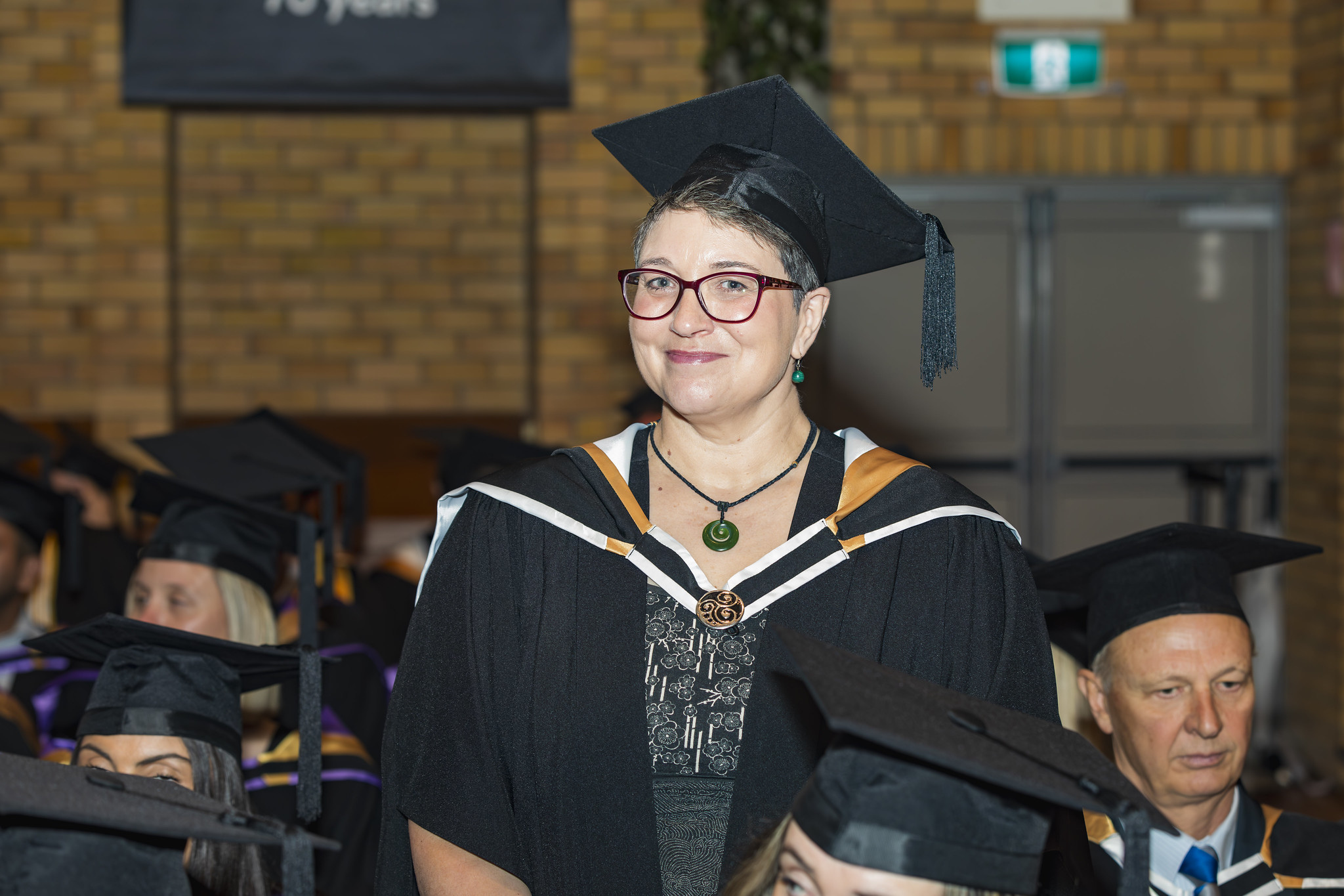 Abigail Whyte in her graduation gown, smiling during her graduation ceremony. 
