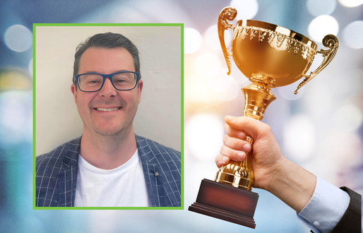 Image of a stylish male academic with glasses and blazer smiles on top of trophy award imagery. 