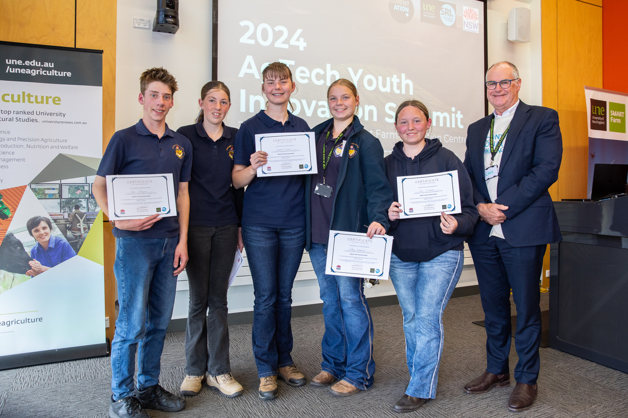 Narrabri High students showing certificates, with UNE VC Pro. Chris Moran standing to the right.