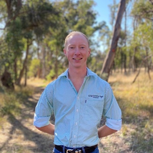 UNE Bachelor of Agriculture student Matthew McCauley in rural setting in UNE shirt